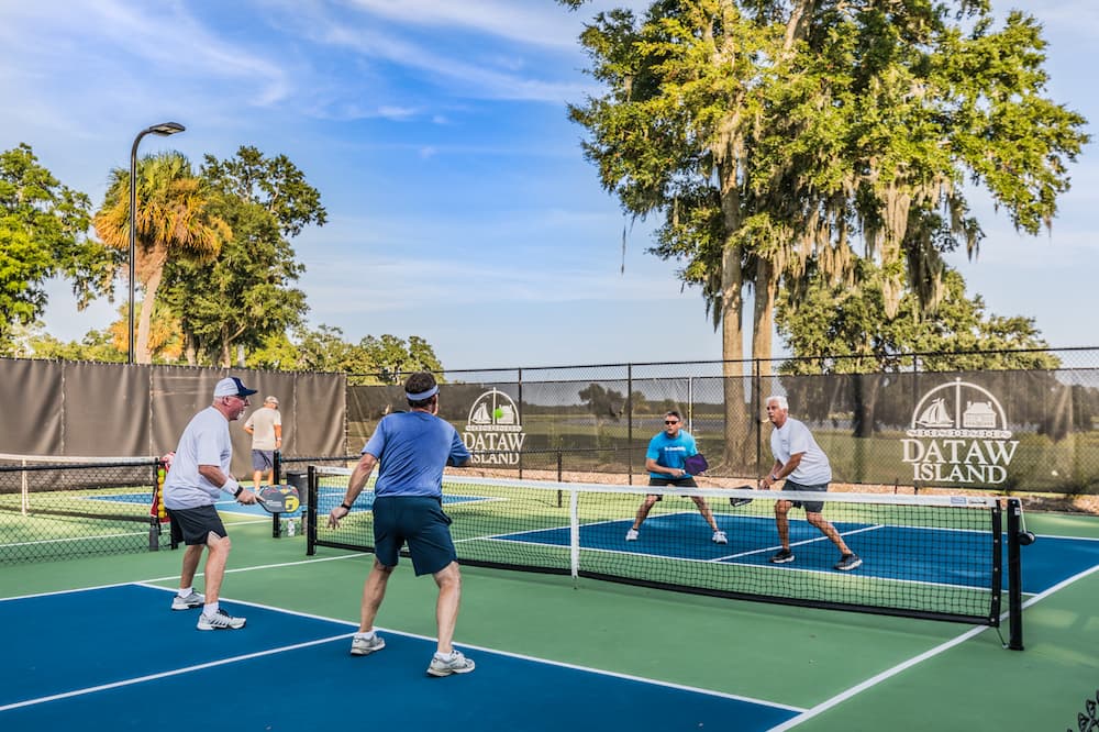 Four men playing pickleball